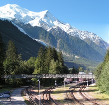 La gare de Chamonix. Au fond, on aperçoit le glacier des Bossons, le Dôme du Goûter et l’Aiguille du Goûter.