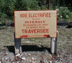Ancien panneau de mise en garde contre les dangers du rail conducteur.