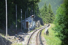 Ce panneau <em>GARE</em> annonce la gare d’Argentière.Il est apposé sur un ancien abri à matériel. À cet endroit, la voie est protégée par des lignes de détection des chutes de pierre.