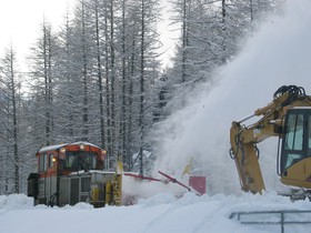 Suite à une avalanche au PK 33, le CN 4 aide une pelleteuse à dégager la voie.